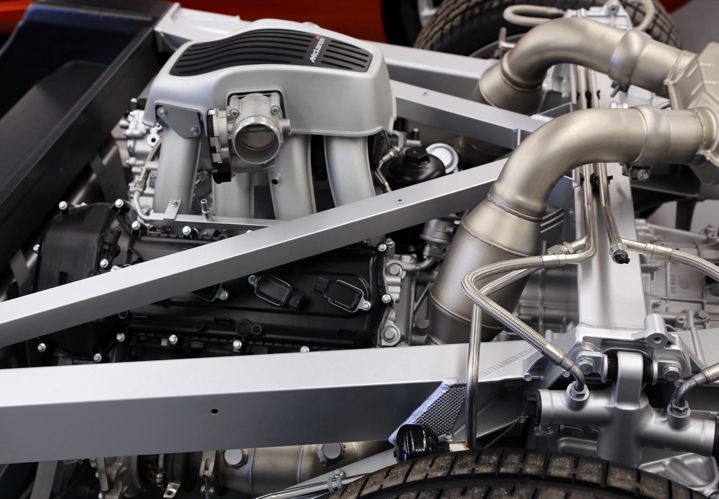 The McLaren M838T twin-turbo V8 engine with its intake plenum and exhaust pipes in a 12C rolling chassis