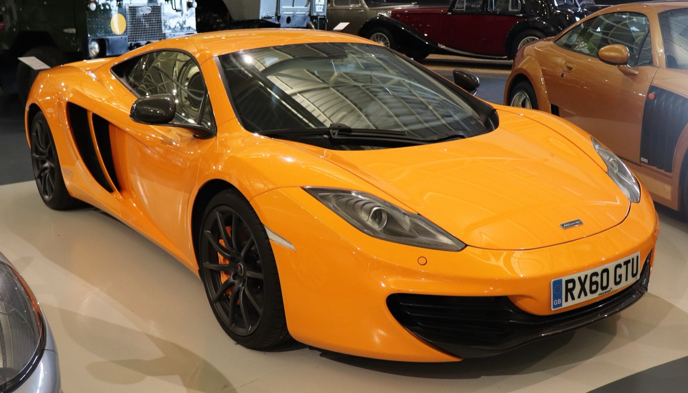 Orange 2011 McLaren MP4-12C coupé on display at a motor museum