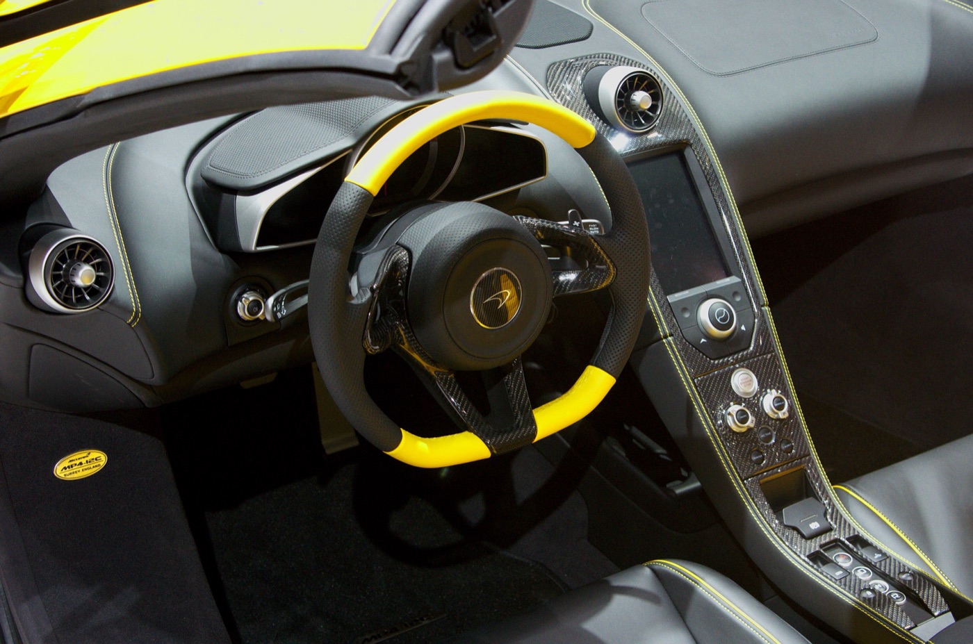 McLaren 12C Spider cabin with a yellow and black steering wheel, carbon-fibre centre console and upright touchscreen