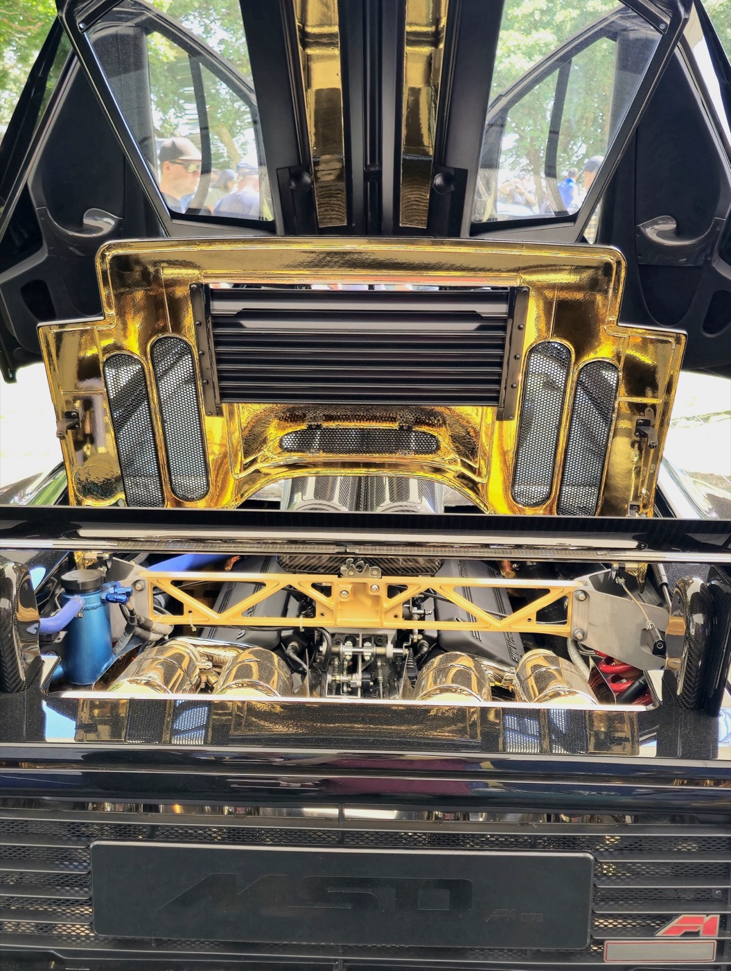 Gold foil lining the engine bay of a McLaren F1 above the V12, with the dihedral doors open