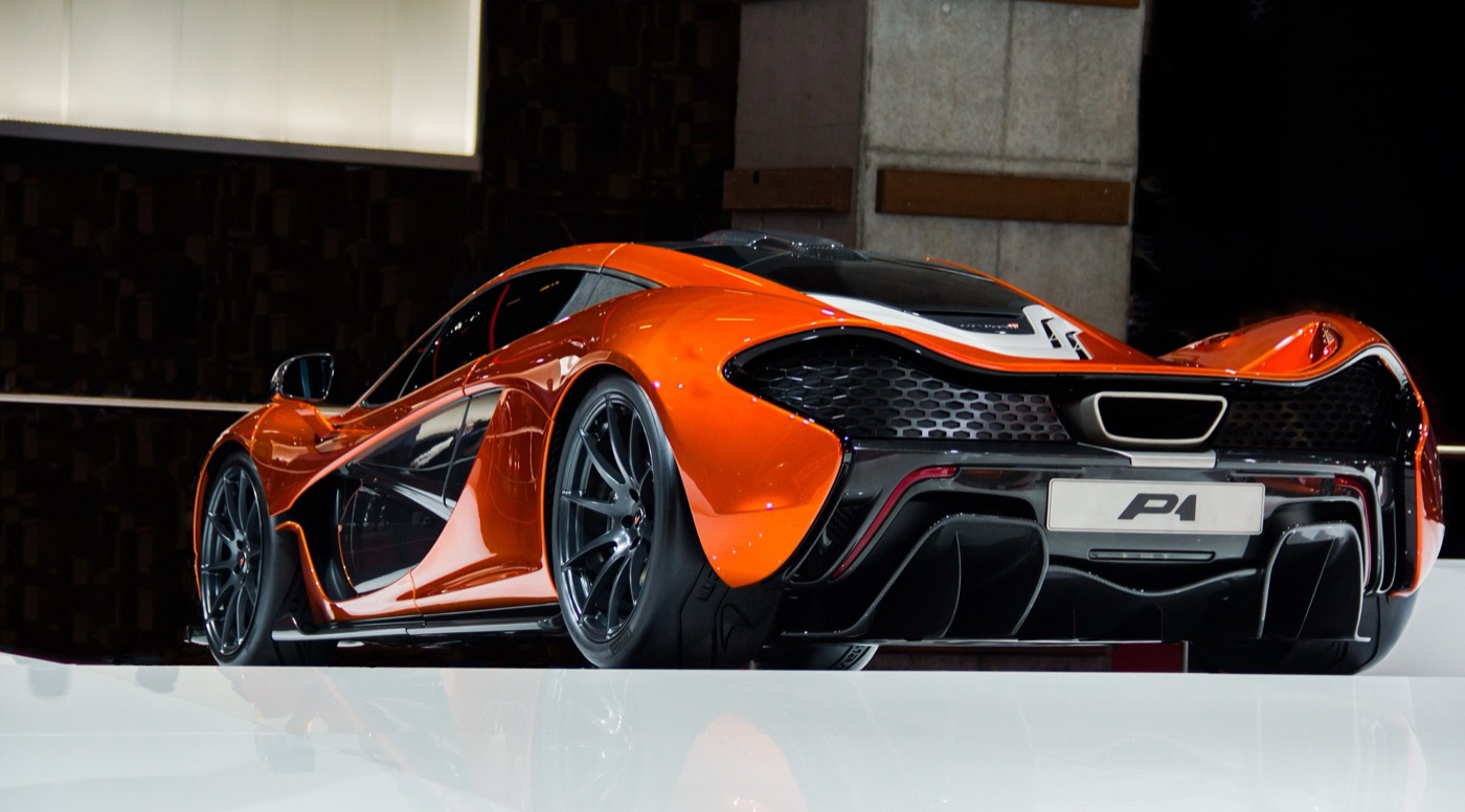 Rear three-quarter view of an orange McLaren P1 showing the mesh tail, the central exhaust and the diffuser