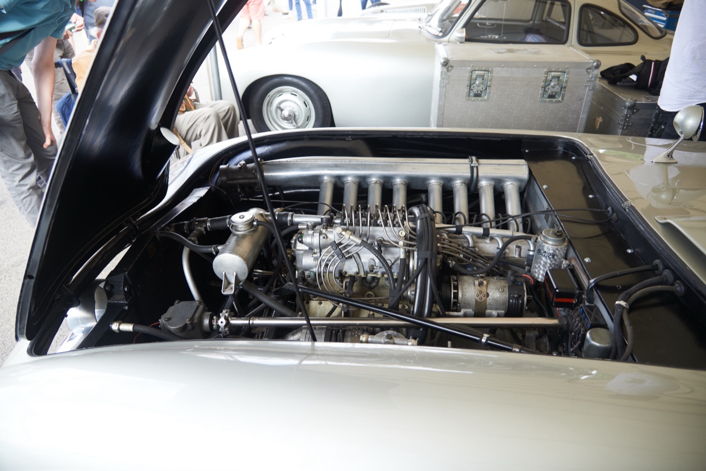 Engine bay of a silver Mercedes-Benz 300 SLR with the bonnet open, showing the straight-eight