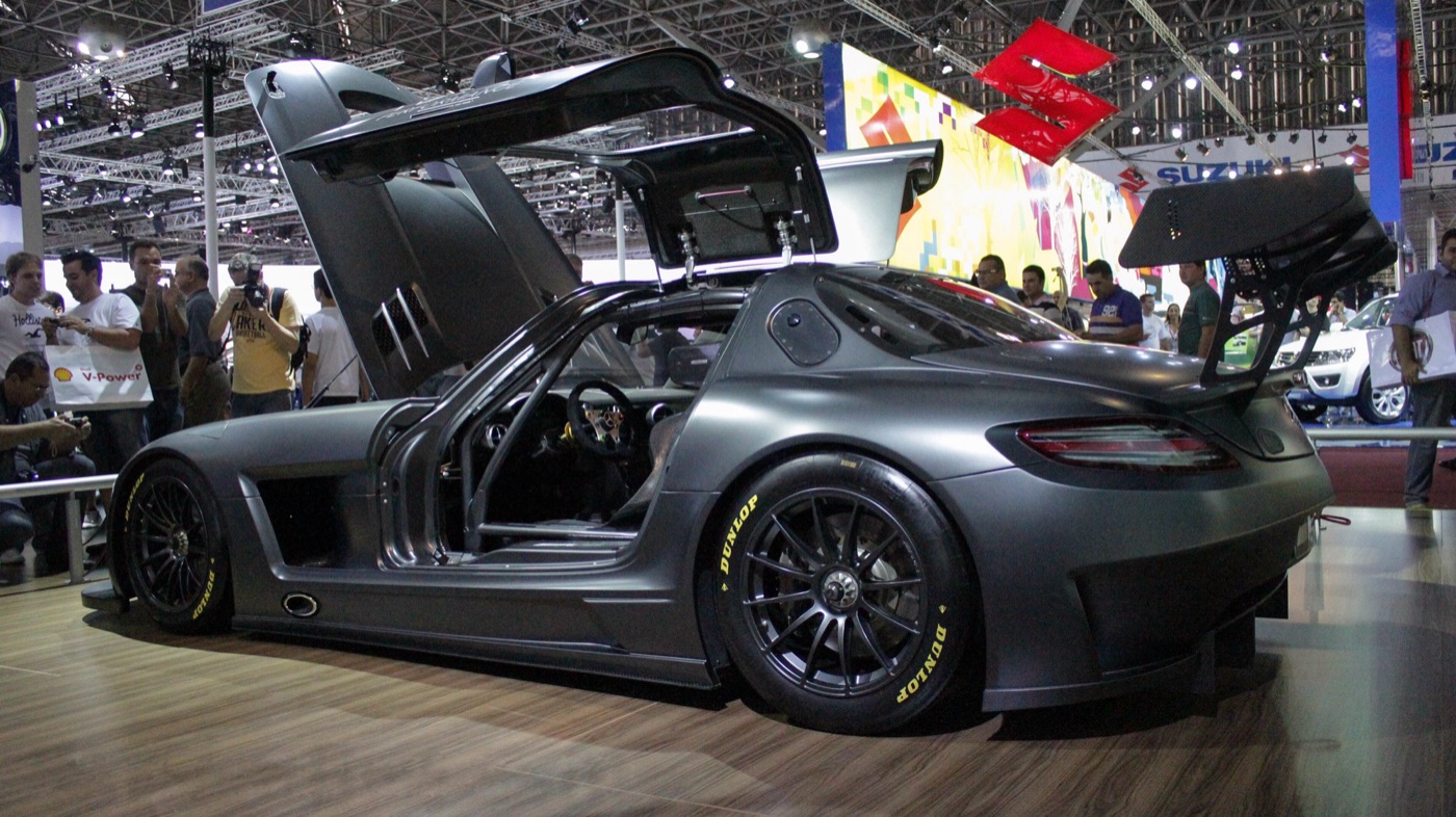 Matt graphite SLS AMG GT3 45th Anniversary racing car with both gullwing doors and the louvred bonnet raised, black wheels, at a motor show