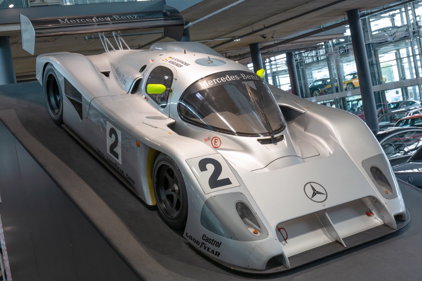 Silver Mercedes-Benz C291 Group C sports prototype with the number 2 and a Mercedes-Benz windscreen banner, on display indoors