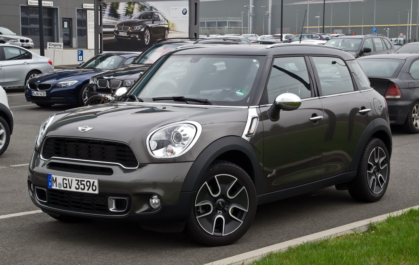 Dark brown MINI Cooper S Countryman ALL4 with chrome mirror caps parked outside a BMW dealer