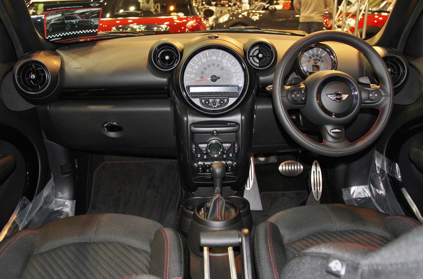 Right-hand-drive dashboard of a MINI John Cooper Works Countryman with the large central speedometer, automatic gear lever and the Center Rail between the seats