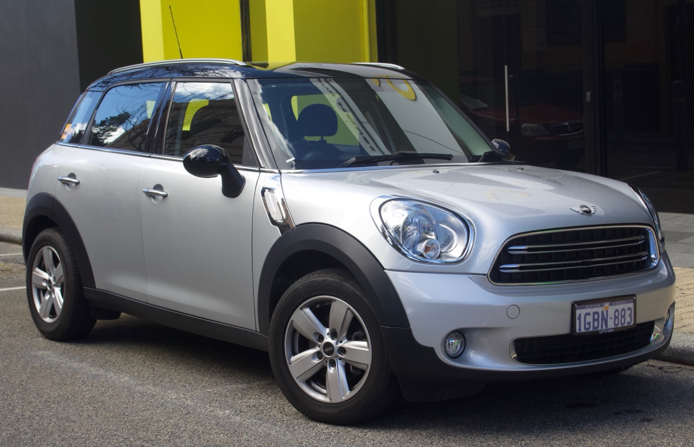 Silver facelifted MINI Cooper Countryman with a black roof parked at a kerb