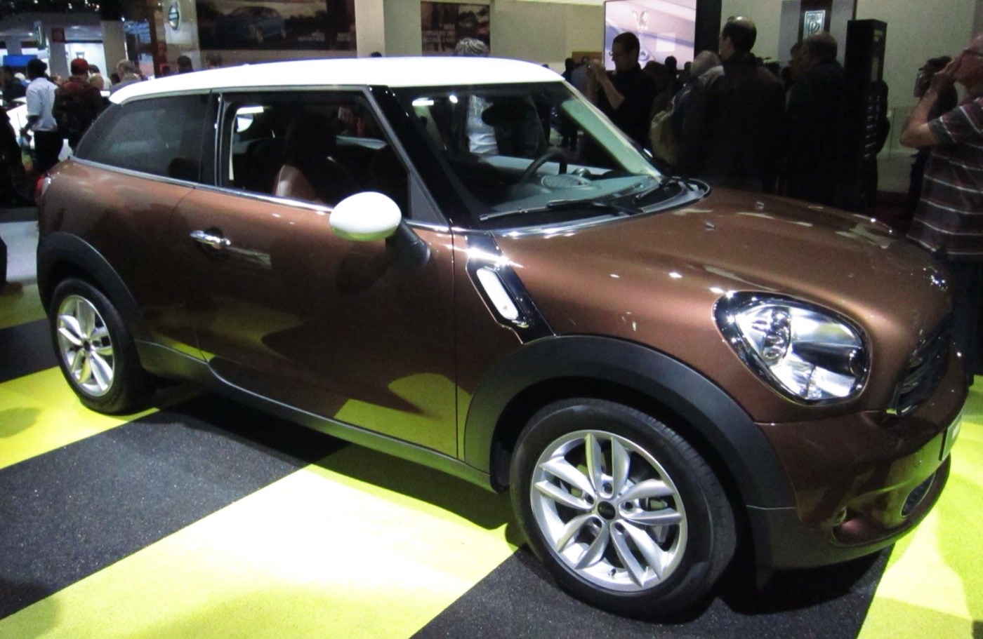 Brown three-door MINI Paceman with a white roof and white mirror caps on a motor show stand