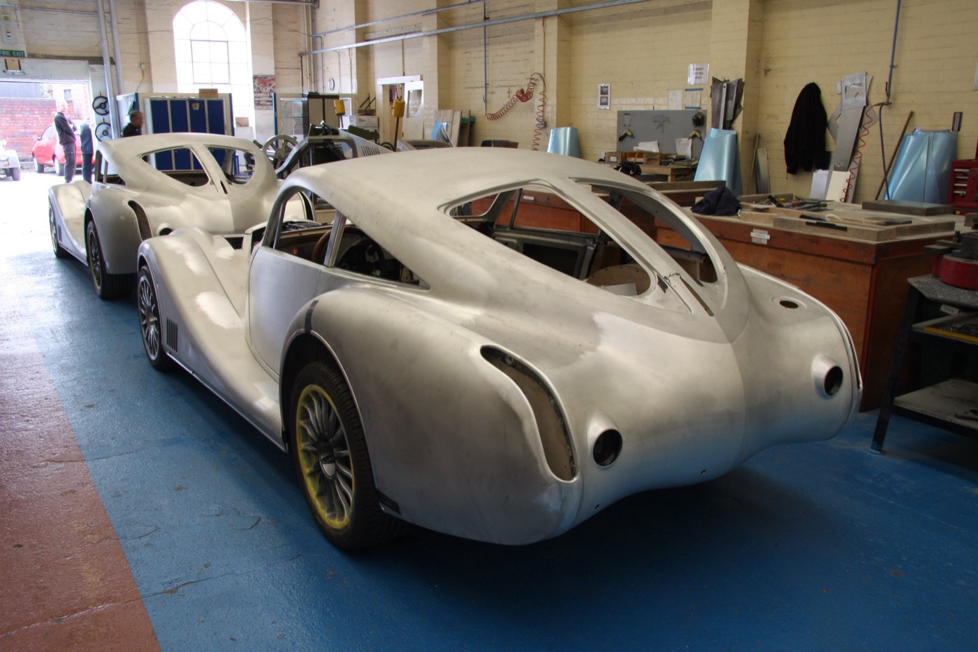 Two unpainted Morgan AeroMax bodies in bare aluminium in the Malvern Link body shop