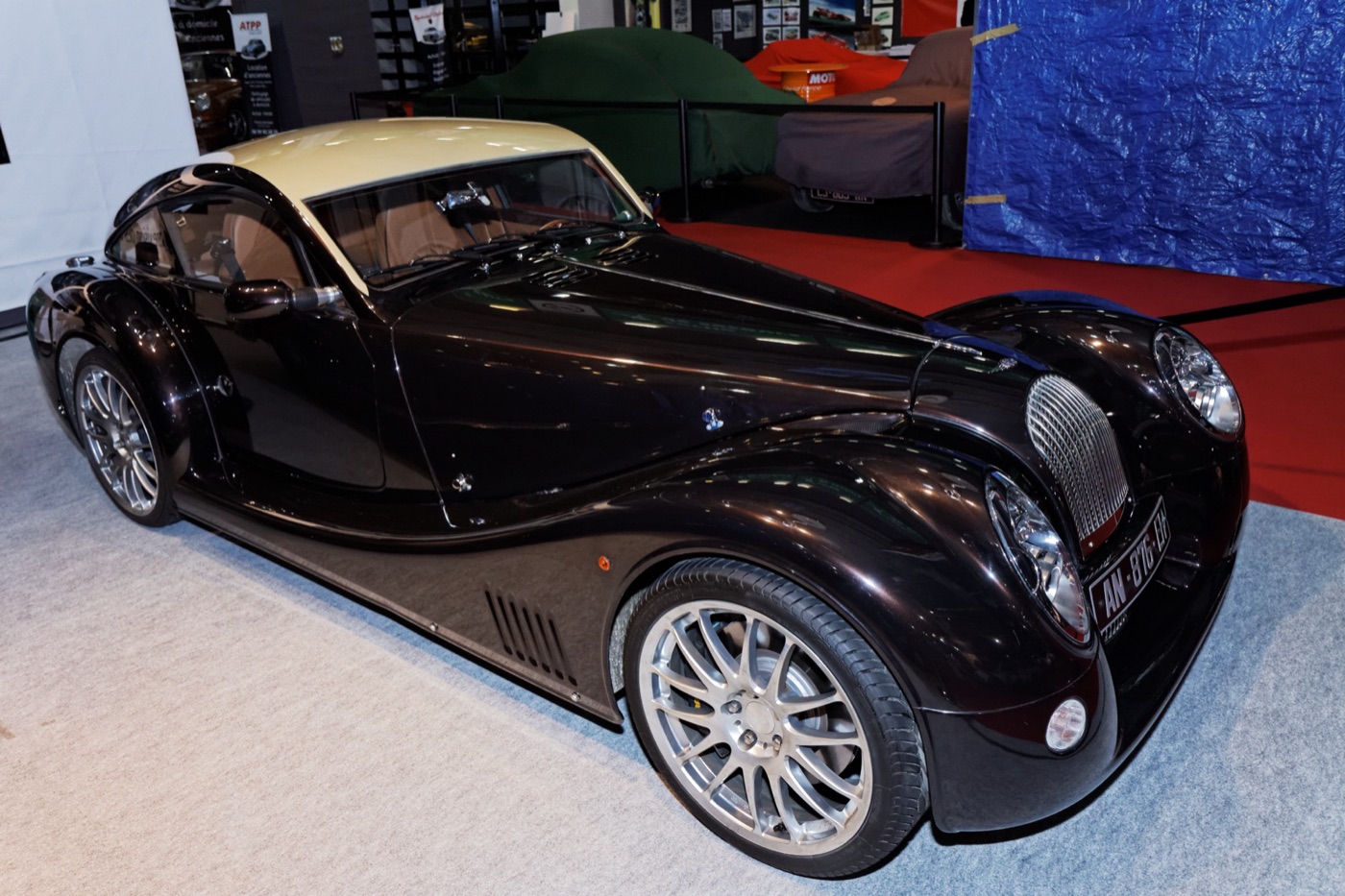 Dark brown Morgan AeroMax with a cream roof on a dealer stand at the Rétromobile show in Paris