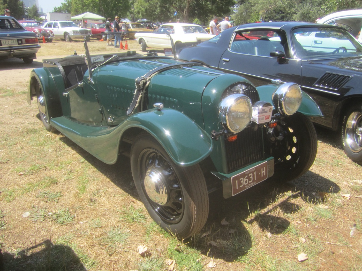 Green 1948 Morgan 4-4 two-seater with a painted radiator cowl and slatted grille, separate headlamps, a fold-flat windscreen and Victorian club-permit plates, at a show on grass
