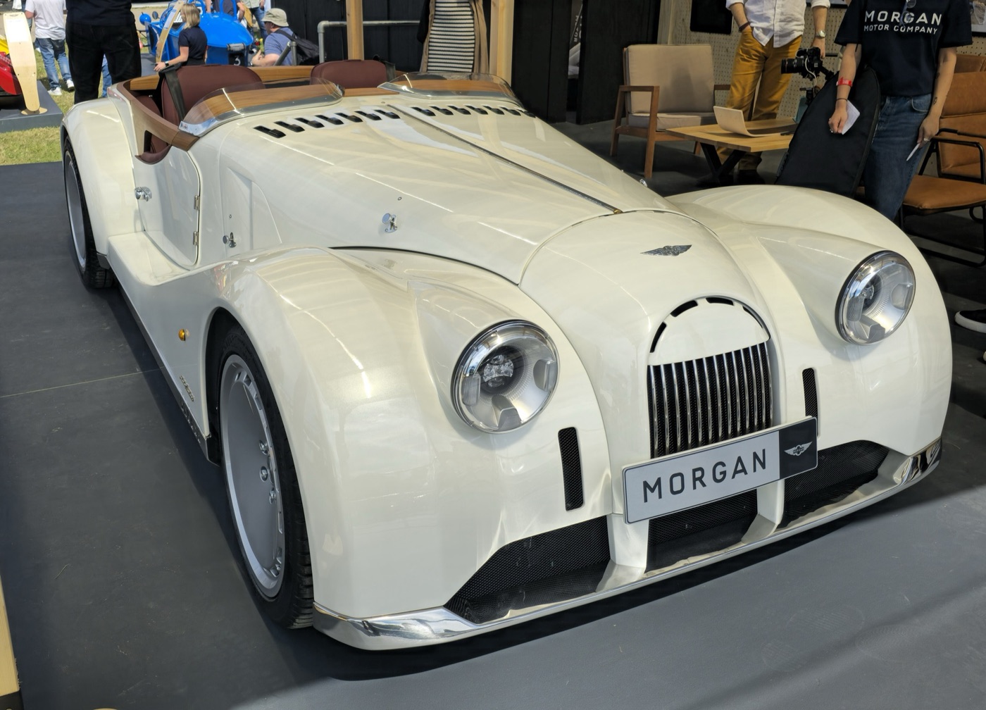 White Morgan Midsummer barchetta with stainless-steel sills, a teak-edged open cockpit and a MORGAN number plate on a show stand