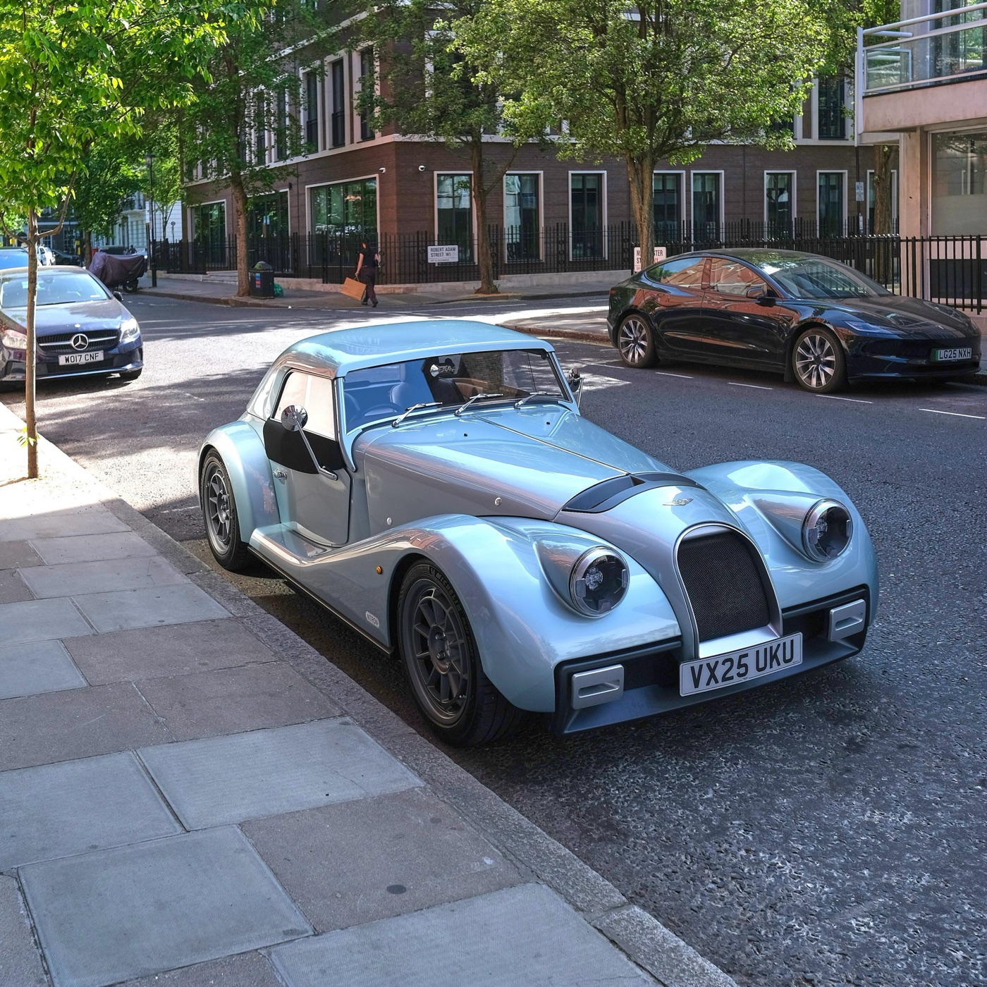 Pale blue 2025 Morgan Supersport with a matching hard top parked at the kerb of a London street