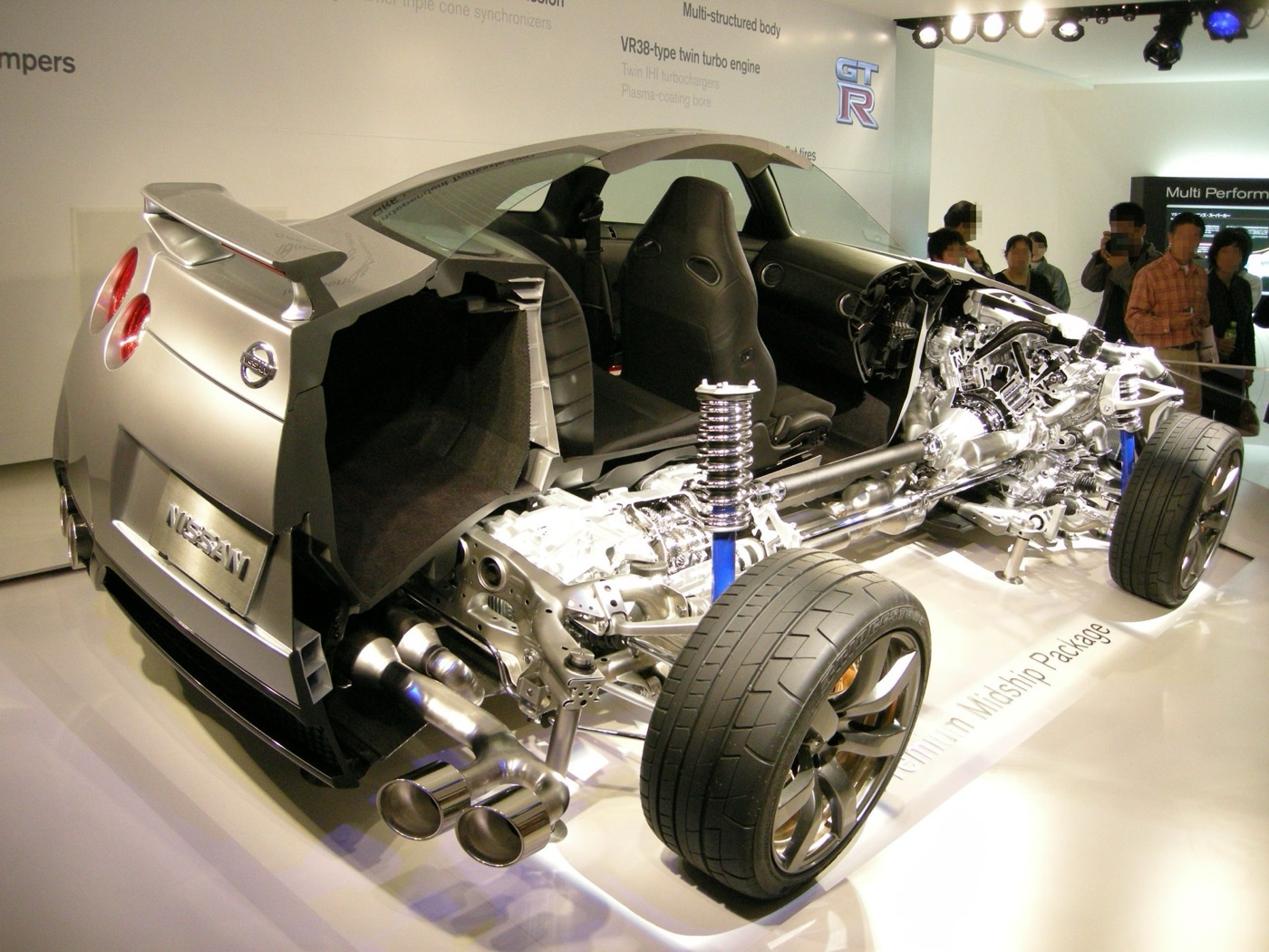 Cutaway Nissan GT-R on a show stand showing the V6 engine at the front, the propshaft and the gearbox mounted at the rear axle