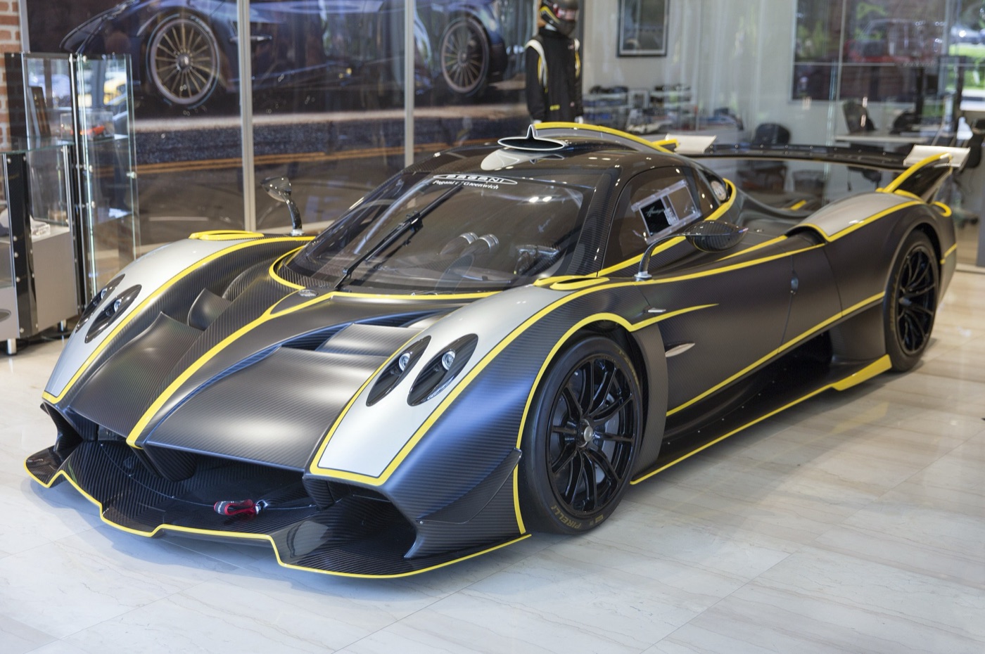 Pagani Huayra R track car in matte exposed carbon with silver and yellow trim, in a showroom