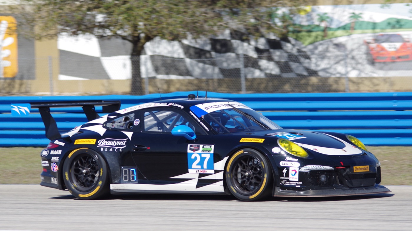 The black and white No. 27 Dempsey Racing Porsche 911 GT America passing the Sebring pit wall