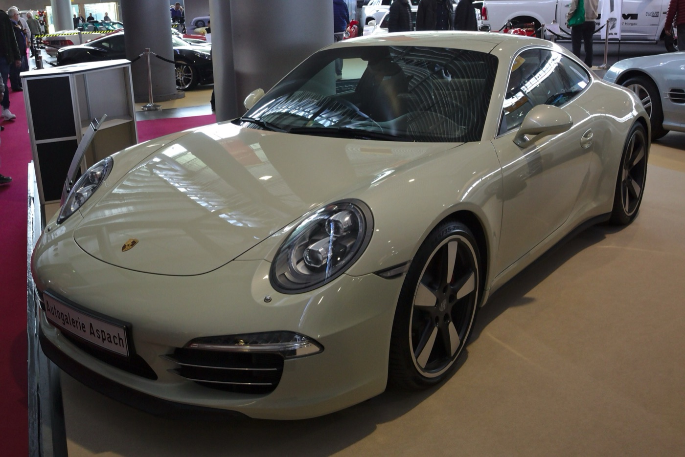 Grey Porsche 911 50 Years Edition of 2013 with Fuchs-style black wheels at a classic car show