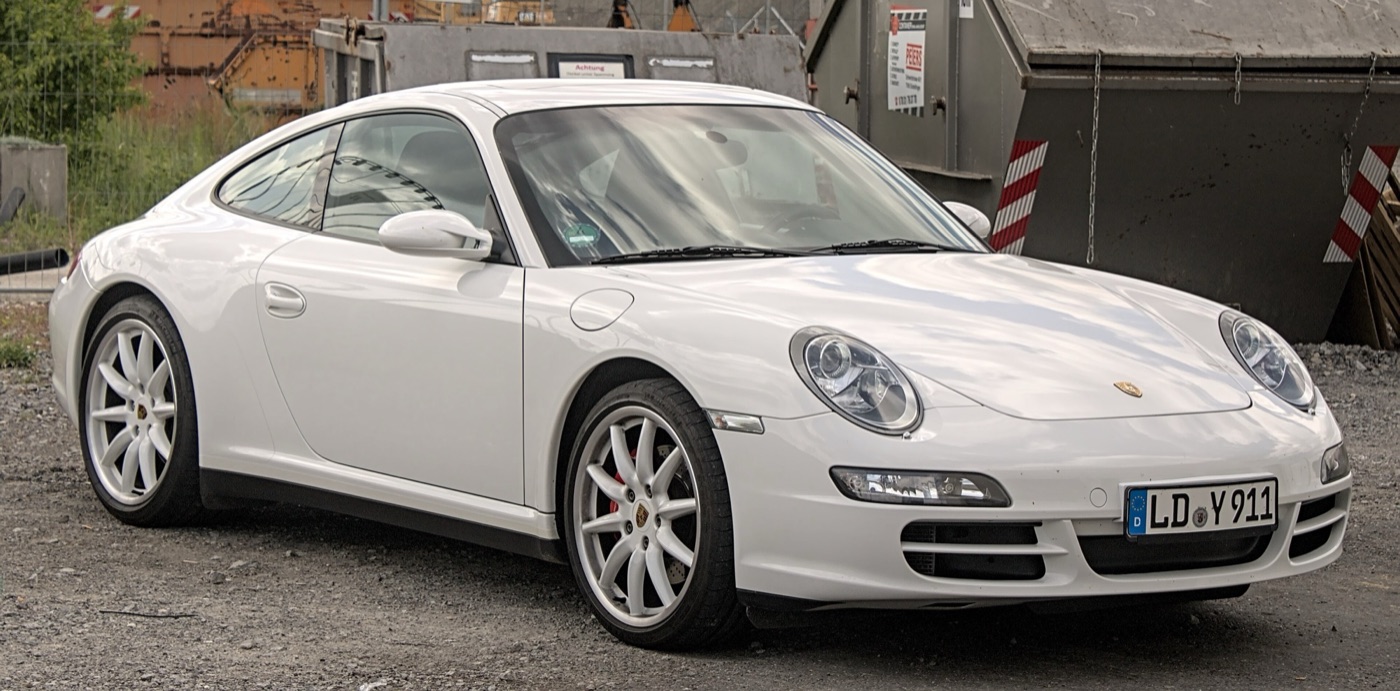White Porsche 997 Carrera coupé with the oval clear-glass headlamps of the sixth-generation 911