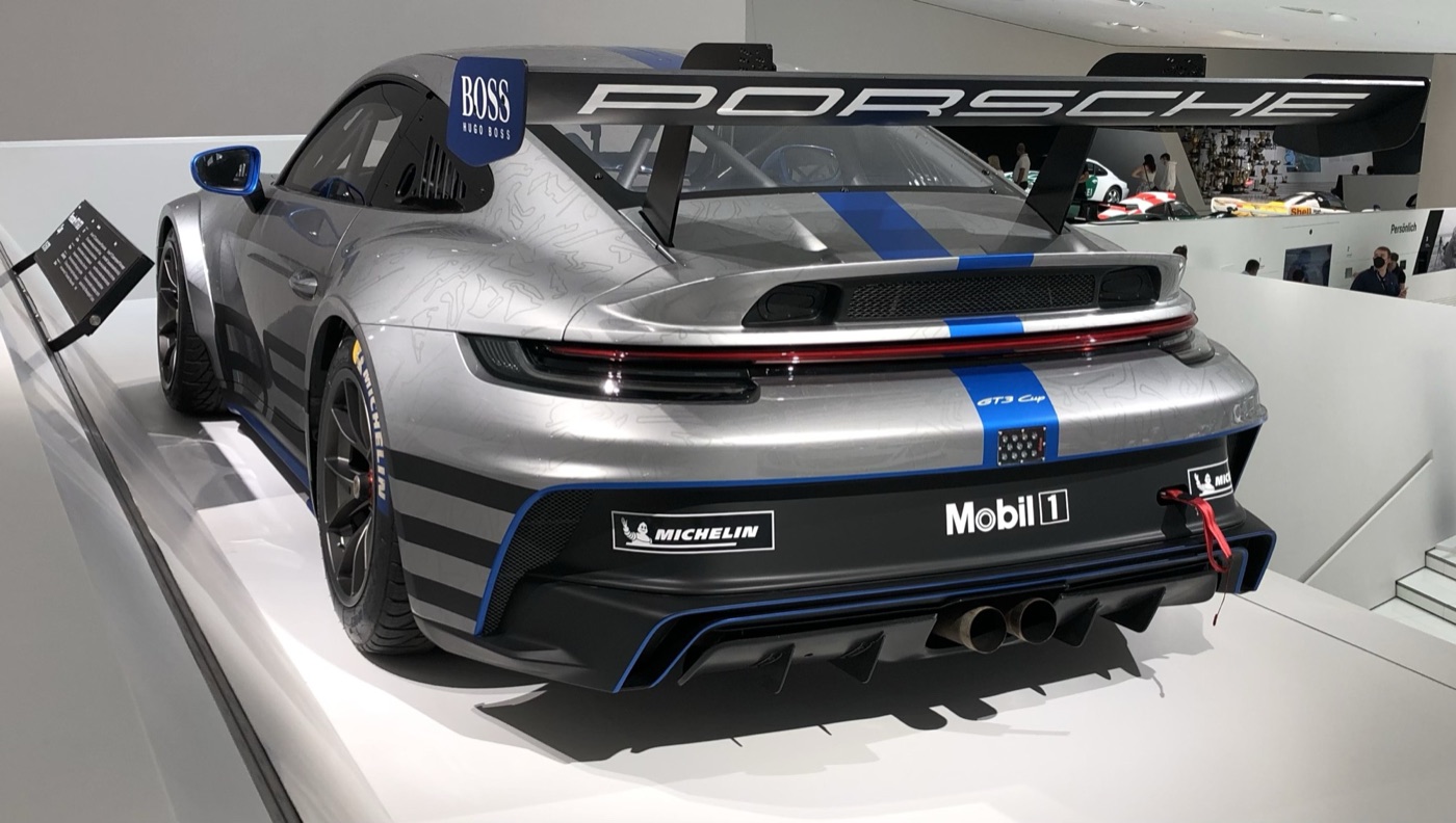 Rear view of a silver and blue 992-generation Porsche 911 GT3 Cup with its swan-neck rear wing, in the Porsche Museum