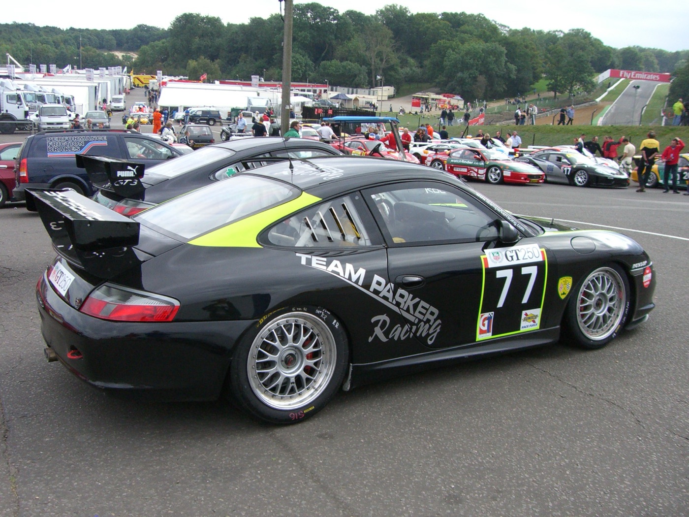 Black 996-generation Porsche 911 GT3 Cup of Team Parker Racing, number 77, in a race paddock