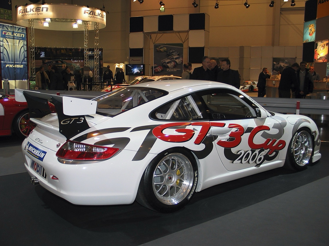 White 997-generation Porsche 911 GT3 Cup with GT3 Cup 2006 graphics on a show stand, seen from the rear three-quarter