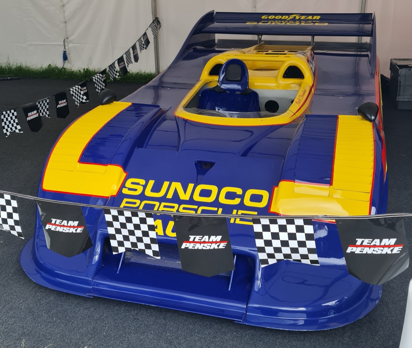 Dark blue and yellow Sunoco Porsche 917/30 Can-Am car with a wide rear wing, seen from the front