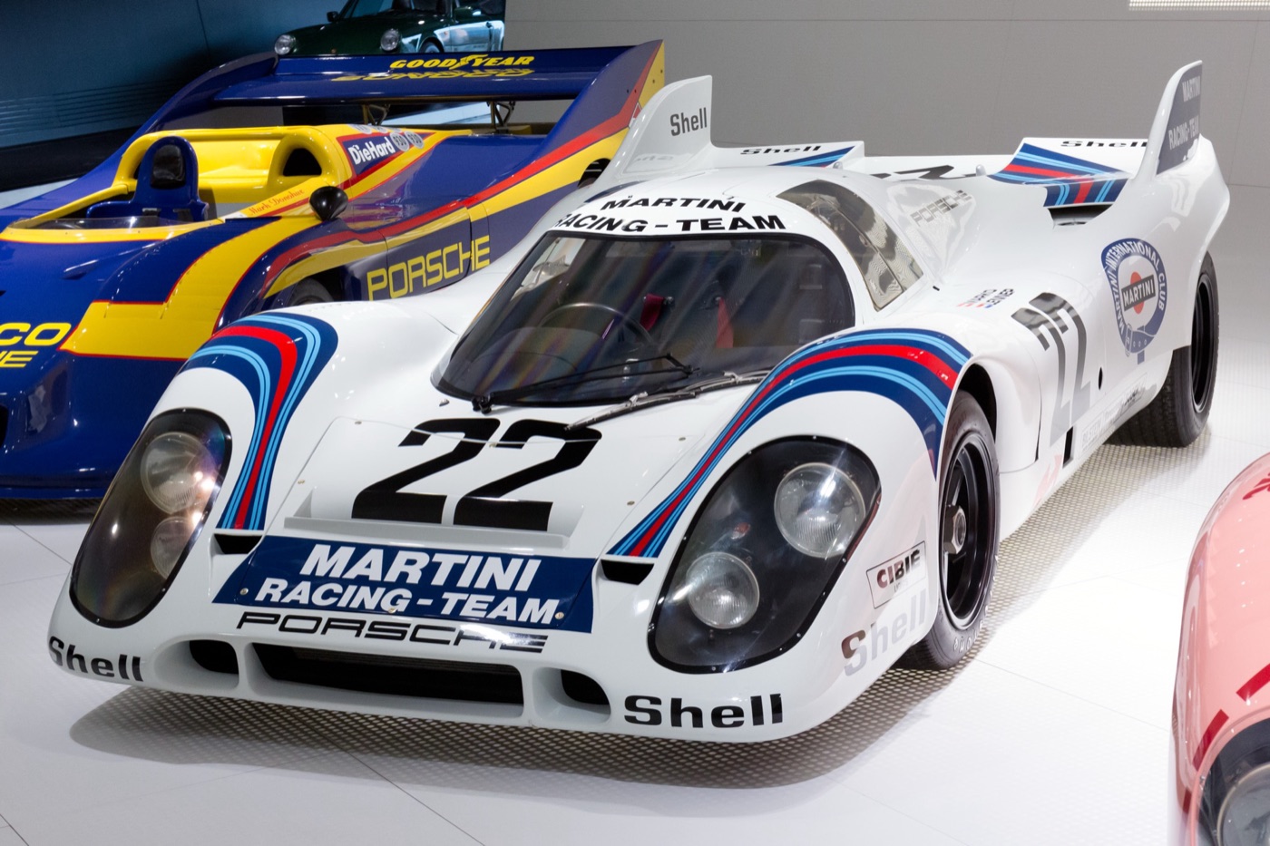 White Martini Racing Porsche 917K number 22 with blue and red stripes and tail fins in a museum