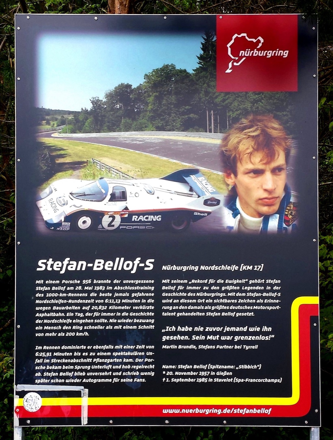 Information board beside the Nordschleife with a photo of a Porsche 956 number 2 in Rothmans colours, a portrait of Stefan Bellof and German text about his record lap