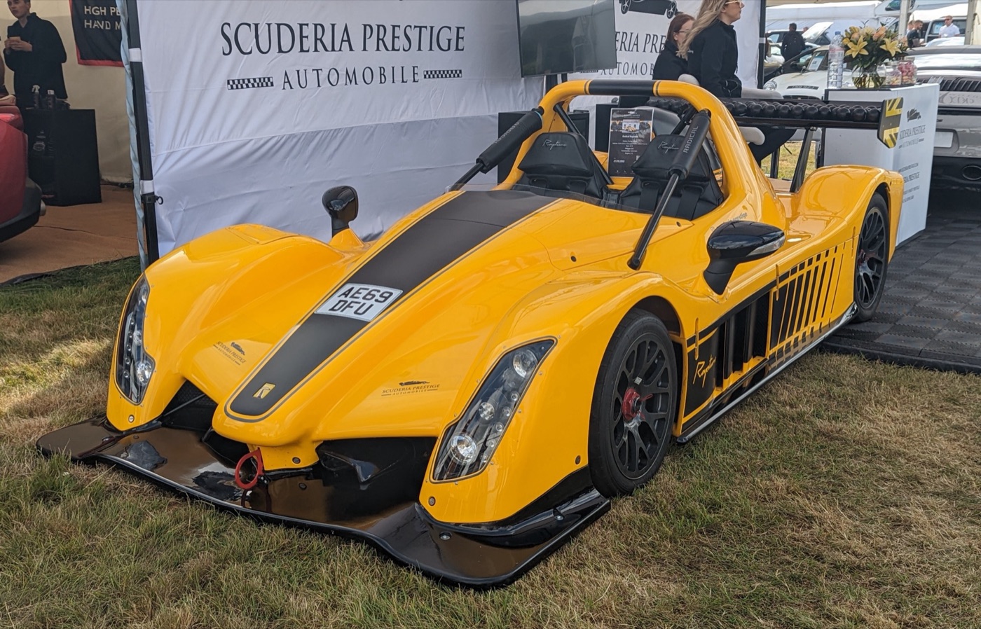 Yellow Radical Rapture with a black centre stripe, number plate and wing mirrors, parked on a show stand