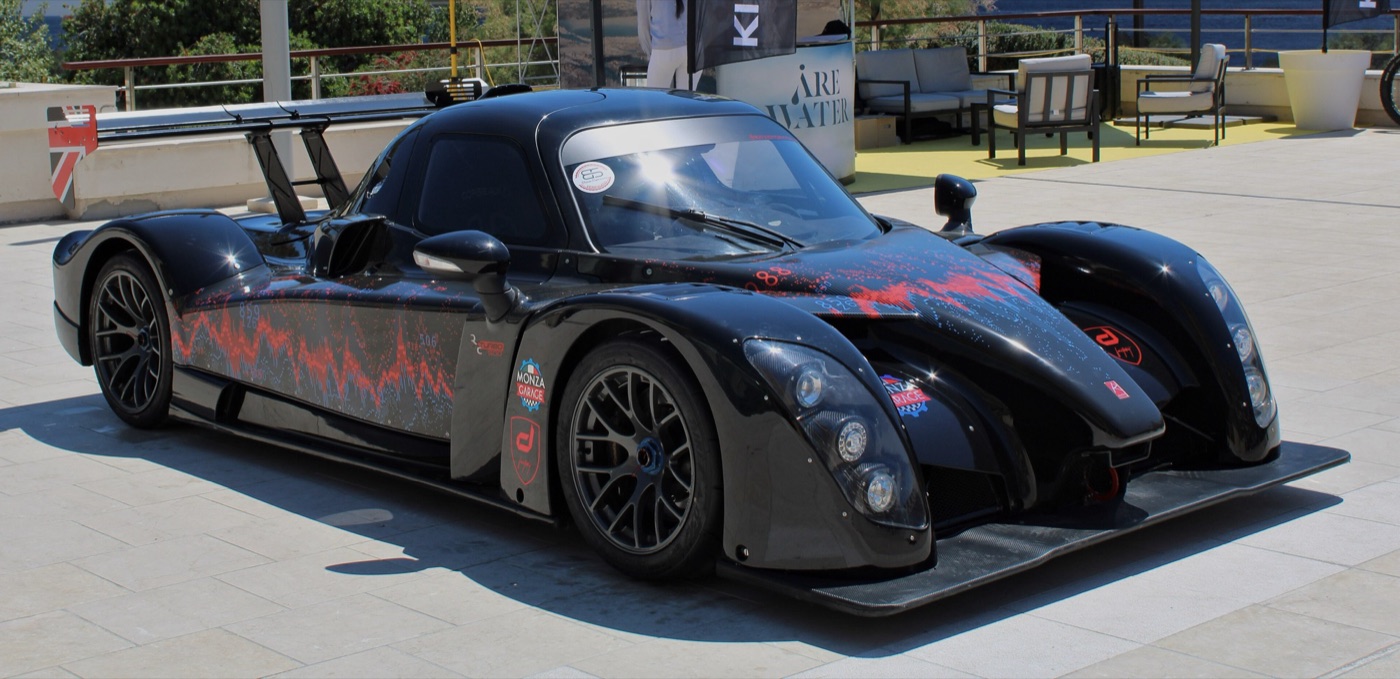 Black Radical RXC Turbo 500 coupé with a large rear wing and red graphics on a show stand