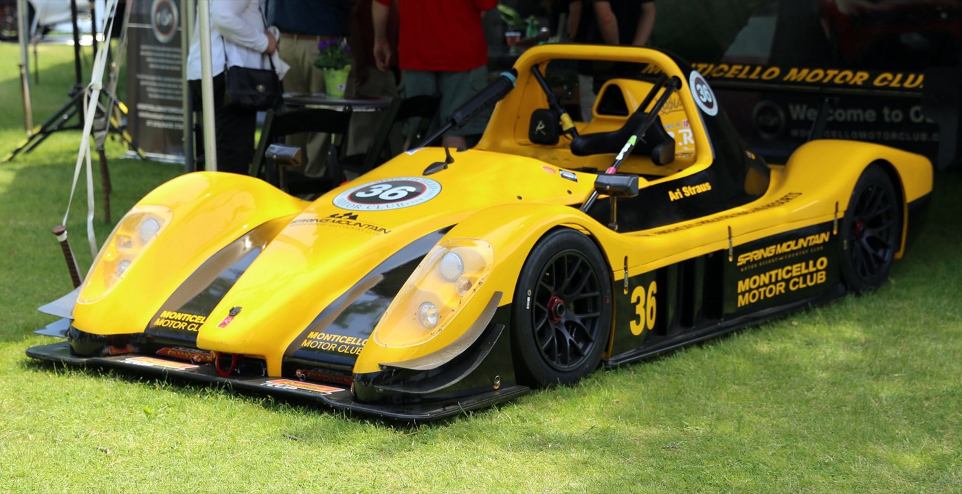 Yellow and black Radical SR8 race car number 36 parked on grass at a show