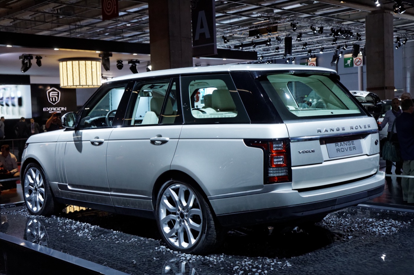 Silver fourth-generation Range Rover Vogue on a dark show stand at the 2012 Paris Motor Show, seen from the rear three-quarter
