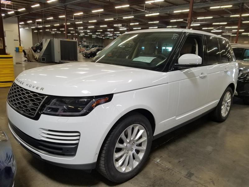 White facelifted fourth-generation Range Rover parked in a large warehouse among other recovered cars