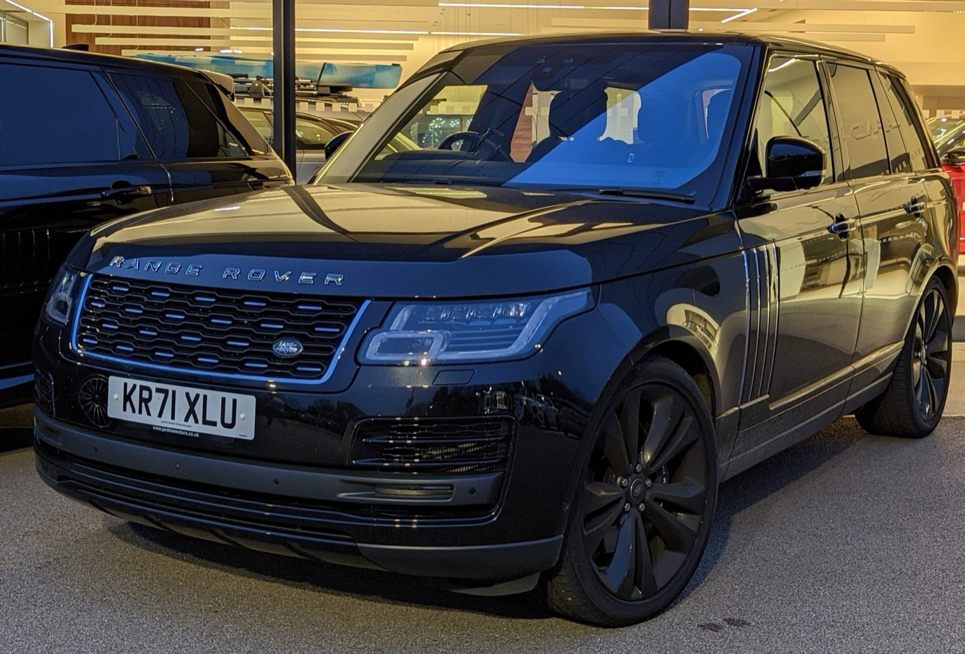 Black facelifted Range Rover SVAutobiography Dynamic with black wheels and a dark mesh grille indoors