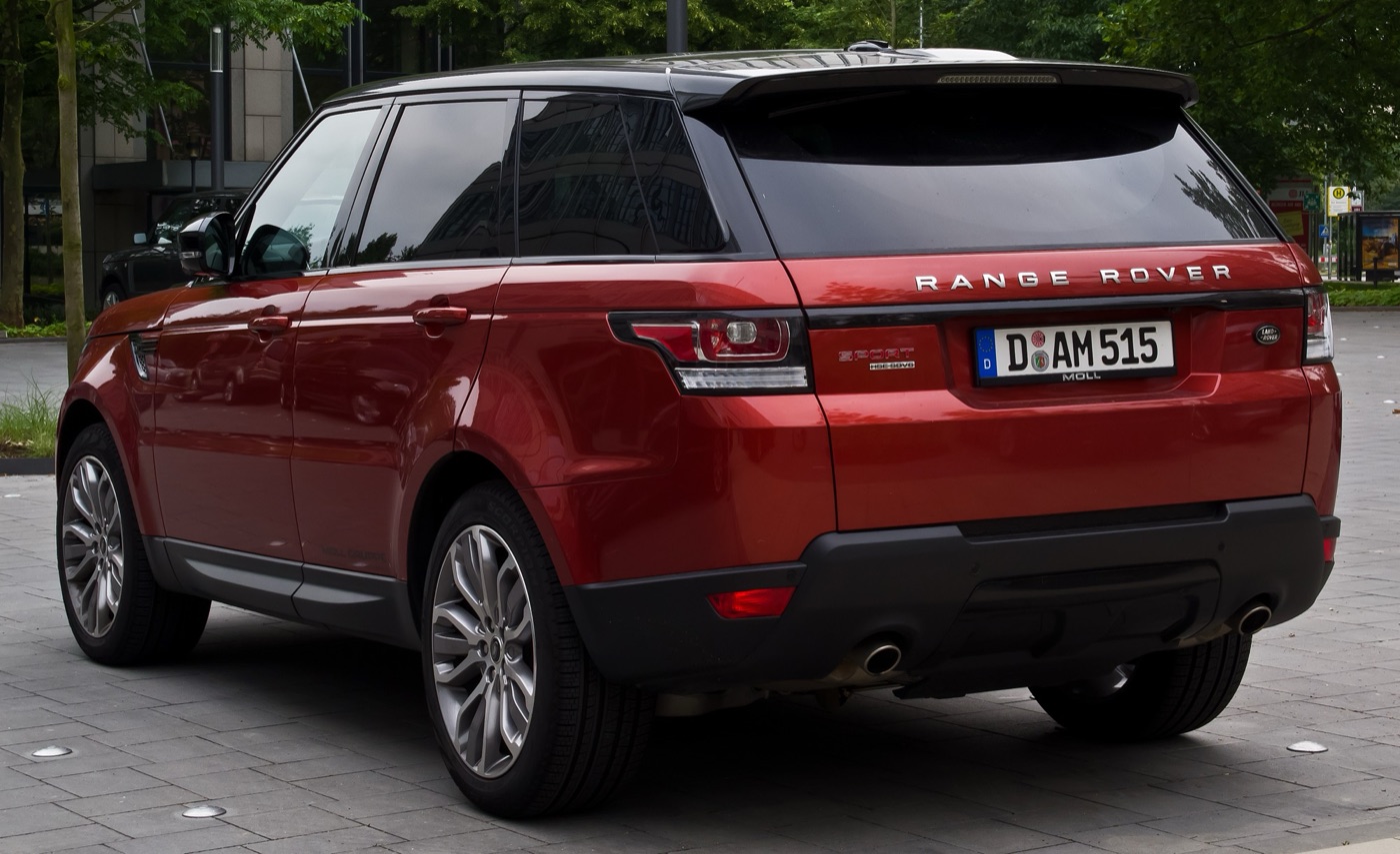 Rear three-quarter view of a red Range Rover Sport L494 SDV6 HSE with a black roof, parked on paving