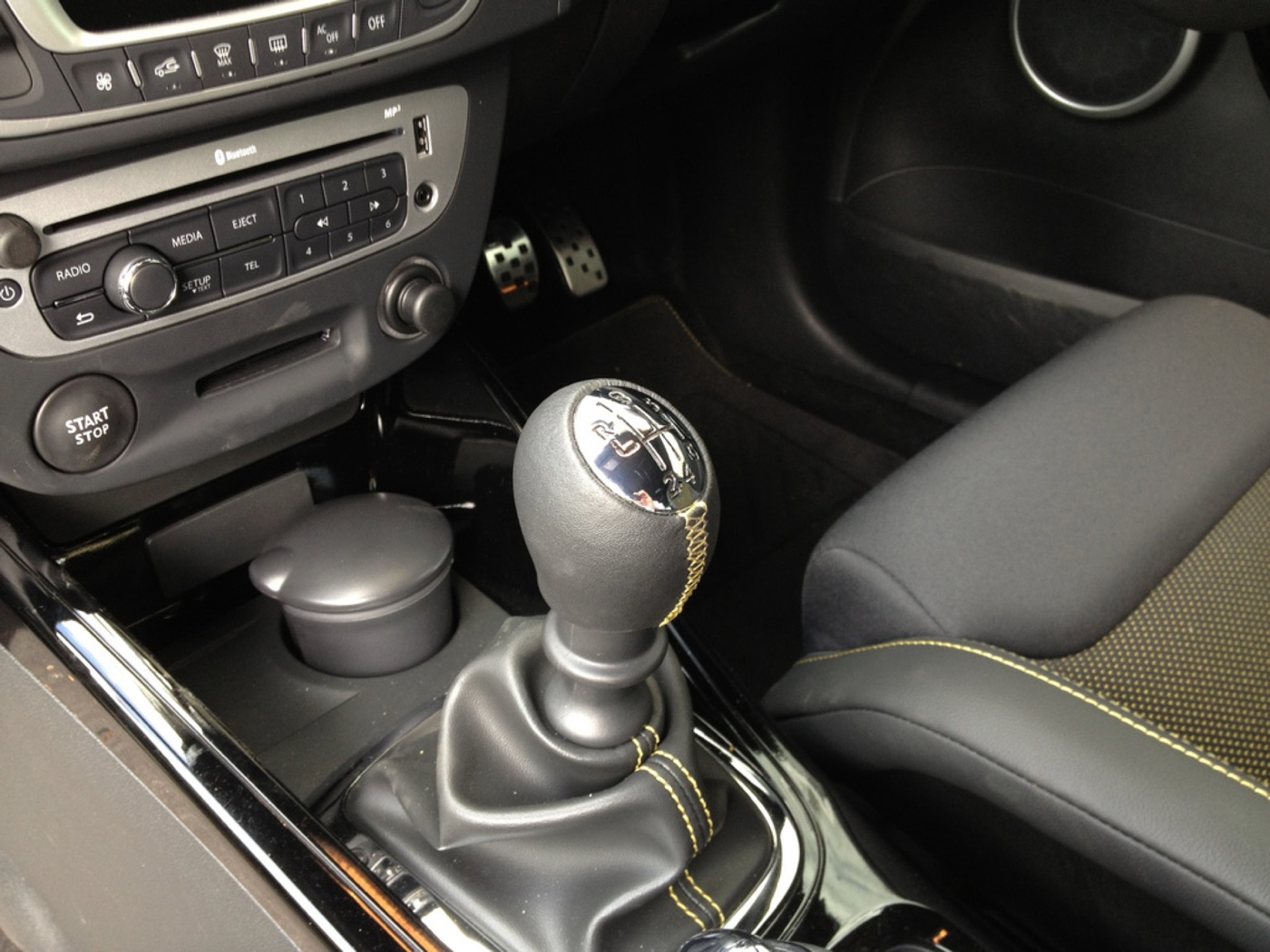 Centre console of a Megane RS 265 with the RS gear knob, yellow stitching, aluminium pedals and the key-card slot