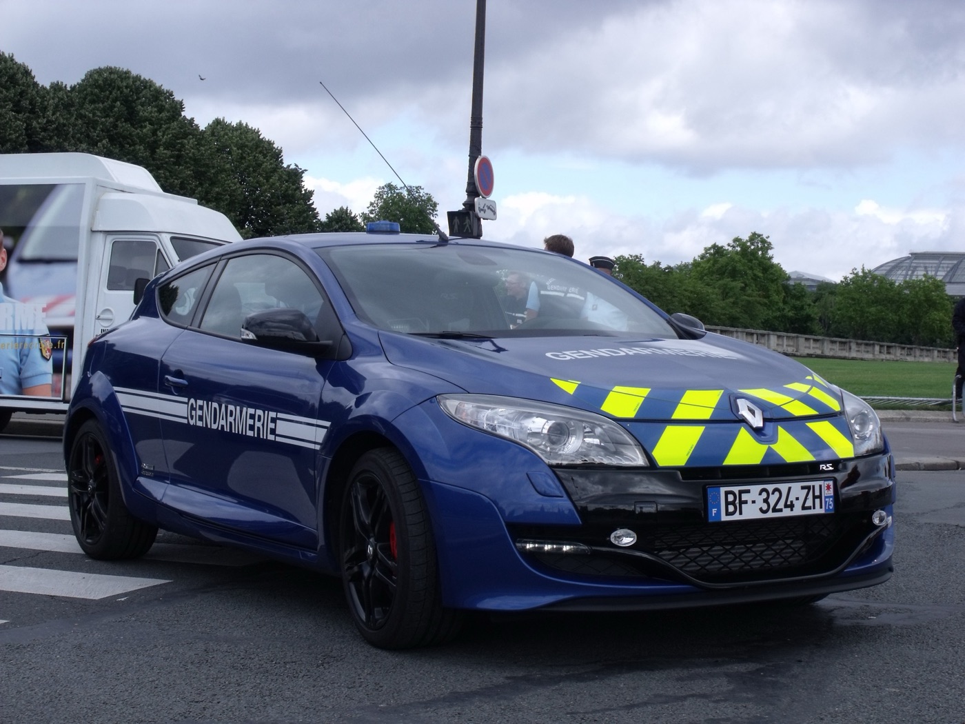 Blue Gendarmerie Megane RS with yellow chevrons on the bonnet and GENDARMERIE lettering on the doors, parked in Paris