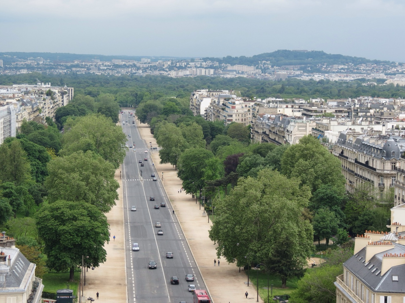 Aerial view down the long tree-lined straight of Avenue Foch towards the Bois de Boulogne, with light traffic