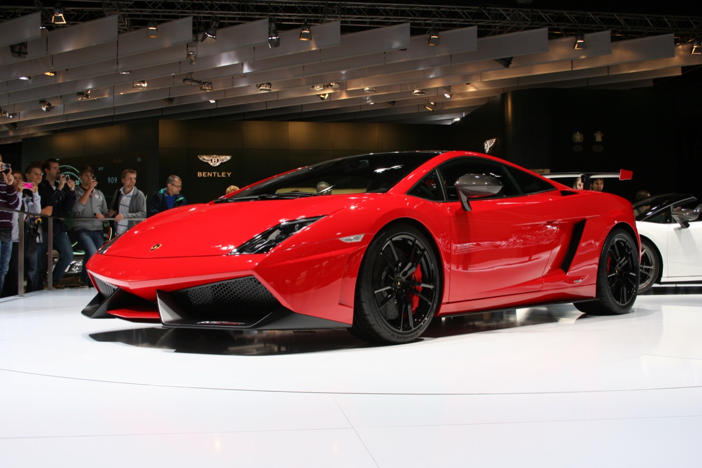Red Lamborghini Gallardo LP 570-4 Super Trofeo Stradale with black wheels on a motor show stand
