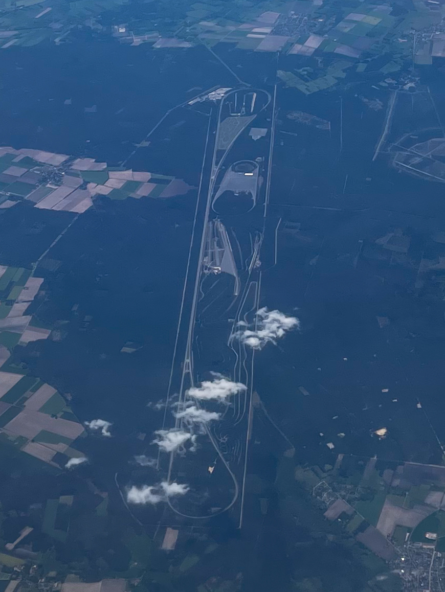 Aerial view of the Volkswagen Ehra-Lessien test track with its long straights and banked turn among forest