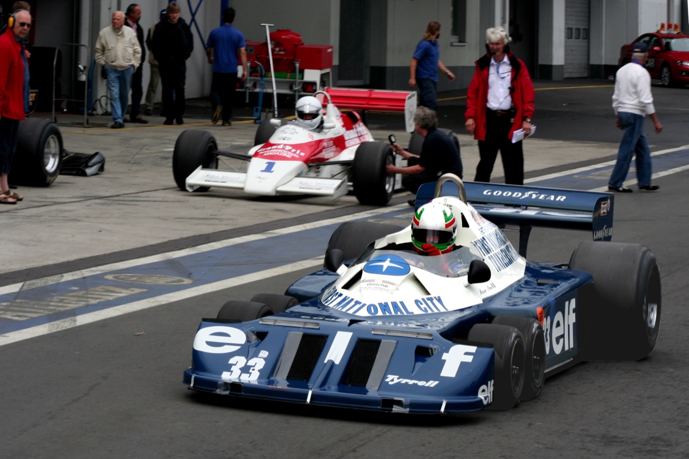 Blue and white six-wheeled Tyrrell P34 number 33 leaving the Nürburgring pit lane at a historic race meeting