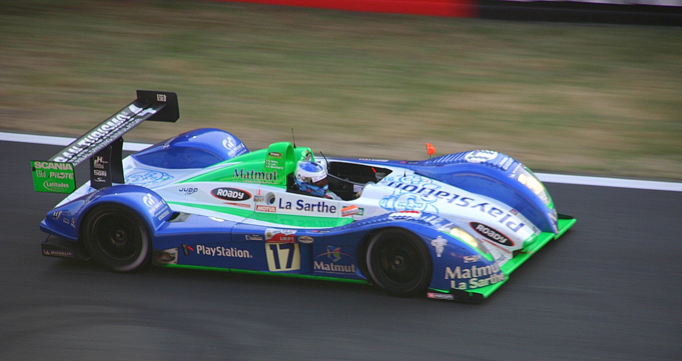 Blue, white and green Pescarolo C60 sports prototype, number 17, at speed on the Le Mans pit straight