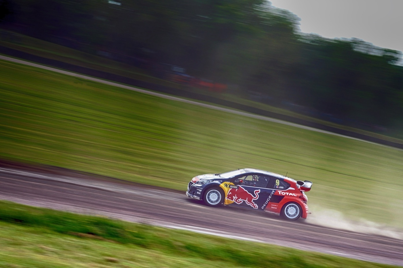 Peugeot 208 WRX rallycross car in Red Bull livery, number 9, kicking up dust on the Lydden Hill circuit
