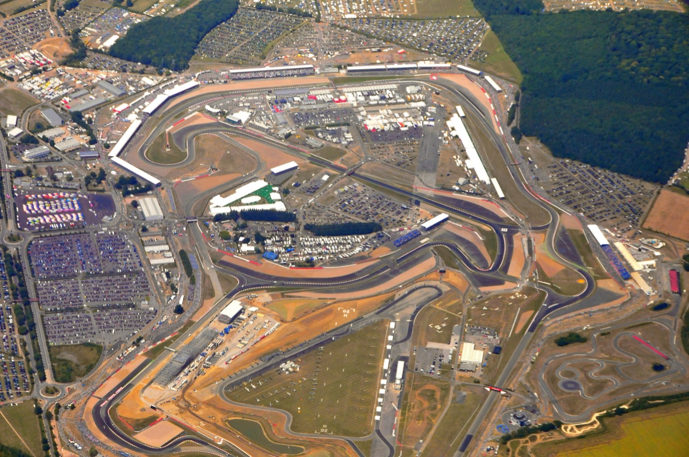 Aerial view of Silverstone on race day in July 2010, with full car parks, grandstands and bare earth where the new pit building was being built beside the circuit