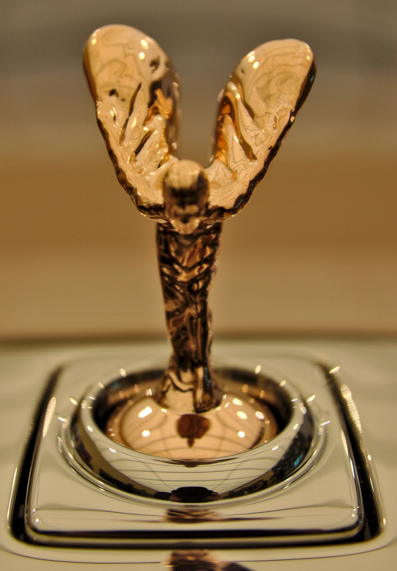 Modern Spirit of Ecstasy seen from the front, standing in the square opening it retracts into on top of a Phantom grille