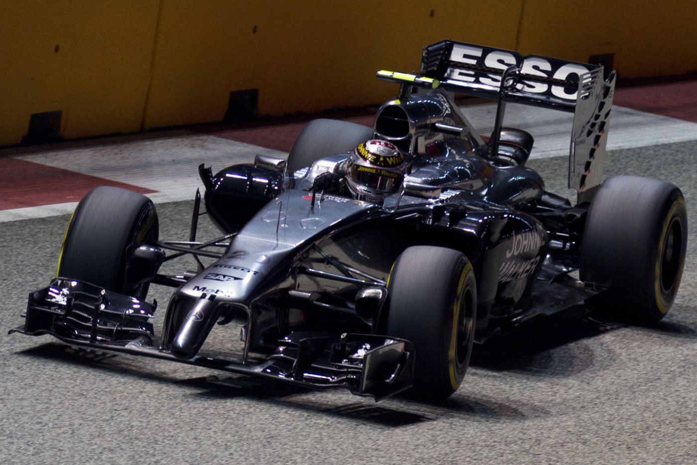 Kevin Magnussen in the black and silver McLaren MP4-29 with an Esso rear wing under the Singapore floodlights