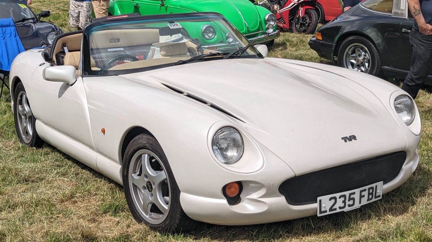 White TVR Chimaera roadster with beige leather interior and the notched front bumper around its indicator, parked on grass