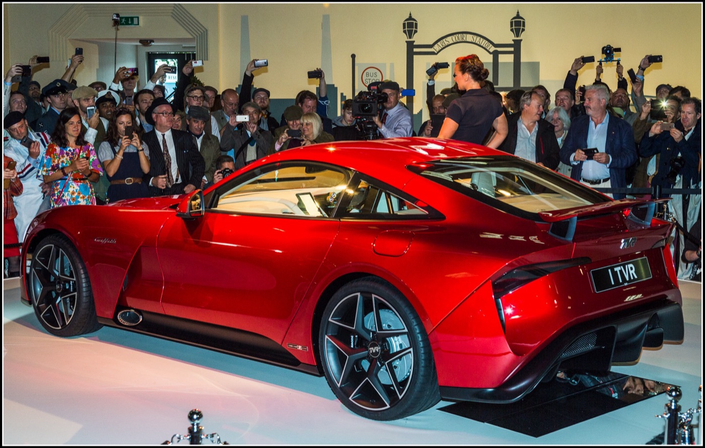 Red 2017 TVR Griffith coupé on a turntable surrounded by a crowd taking photographs at its launch