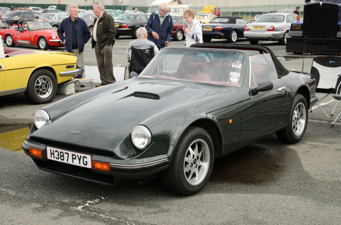Dark green TVR S3 convertible with round headlamps and red leather seats parked at a classic car meeting