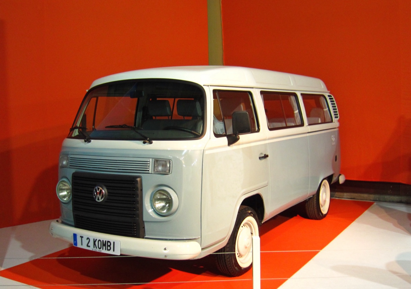 Light blue and white 2013 Volkswagen Kombi Last Edition with whitewall tyres and a T2 KOMBI number plate on a red show stand